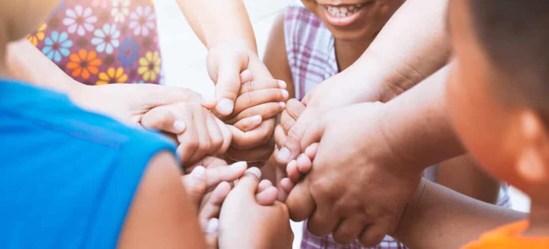Children and parent holding hands and playing together with unity and teamwork